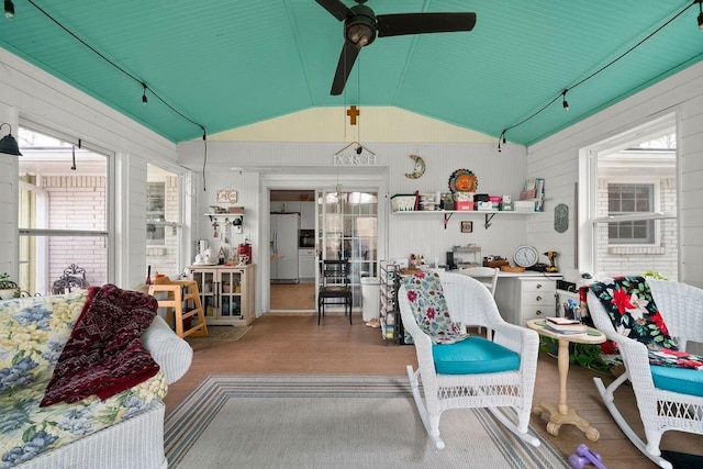 interior space with ceiling fan, hardwood / wood-style floors, lofted ceiling, and a healthy amount of sunlight