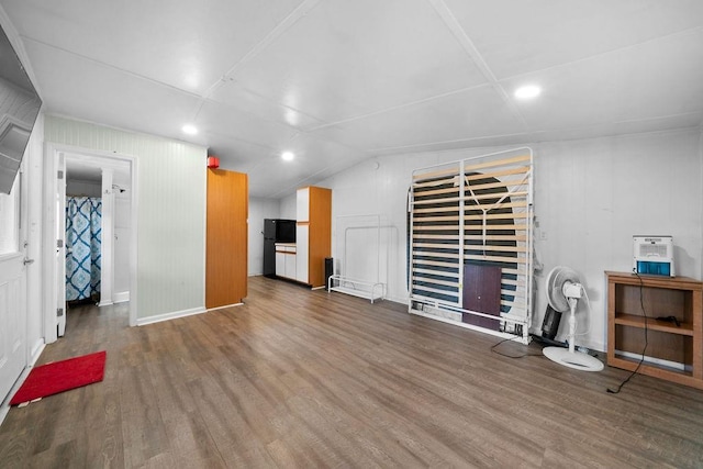 unfurnished living room with hardwood / wood-style floors and vaulted ceiling