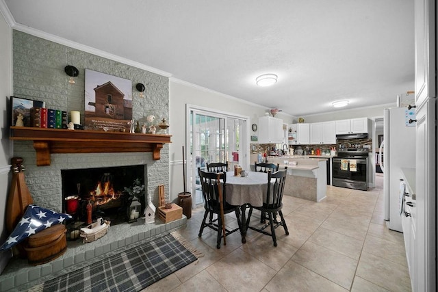 tiled dining room featuring sink, crown molding, and a fireplace