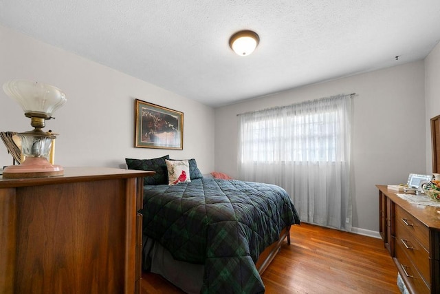 bedroom with wood-type flooring and a textured ceiling