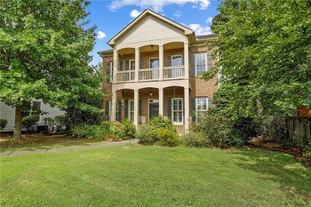 view of front of house featuring a balcony and a front lawn