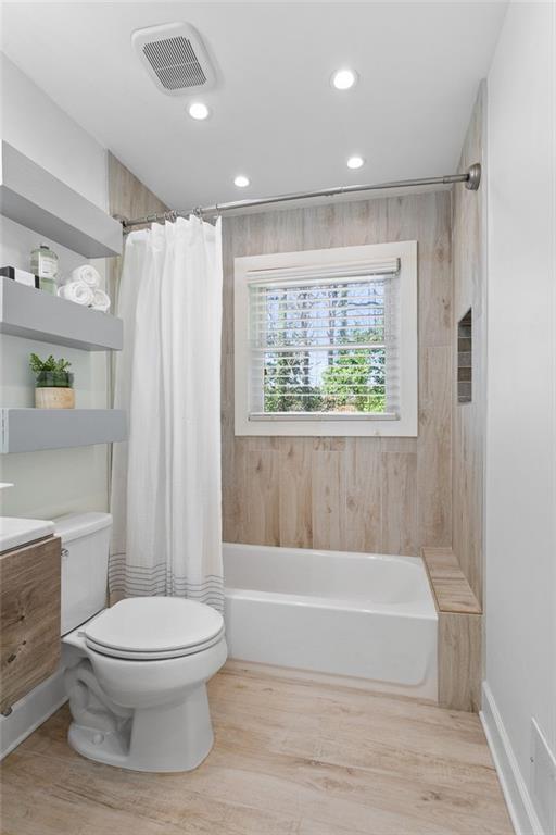 bathroom featuring visible vents, toilet, recessed lighting, wood finished floors, and vanity