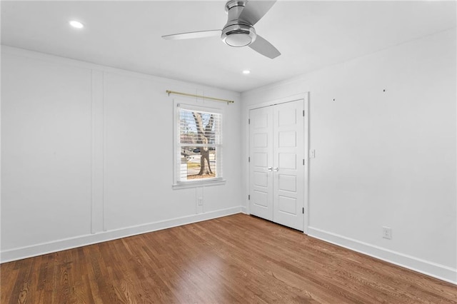 unfurnished bedroom with recessed lighting, a ceiling fan, baseboards, and wood finished floors