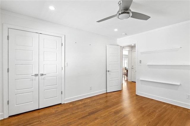 unfurnished bedroom with baseboards, recessed lighting, wood finished floors, a closet, and a ceiling fan