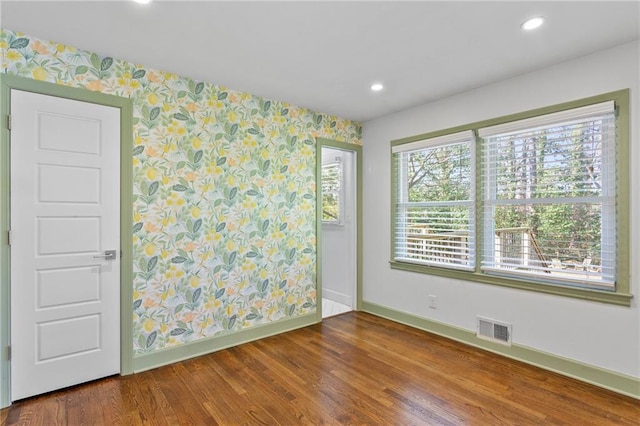 spare room with visible vents, wood finished floors, recessed lighting, wallpapered walls, and baseboards