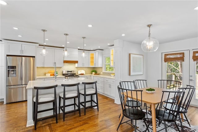 dining room with recessed lighting, french doors, a healthy amount of sunlight, and wood finished floors