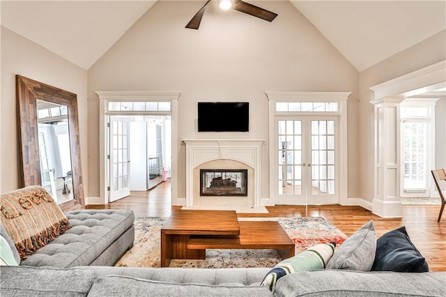 living area featuring french doors, wood finished floors, a healthy amount of sunlight, and ceiling fan