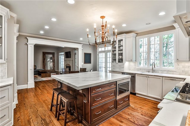 kitchen featuring a breakfast bar area, white cabinetry, stainless steel appliances, and a sink