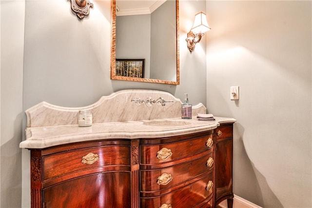 bathroom with vanity, crown molding, and baseboards