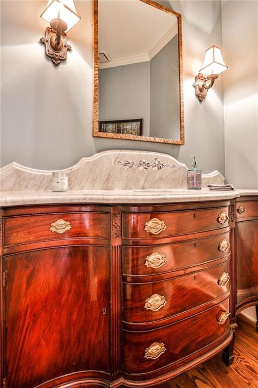 bathroom with vanity, crown molding, and wood finished floors