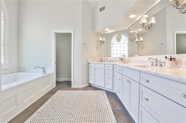 bathroom featuring double vanity, visible vents, an inviting chandelier, and a sink