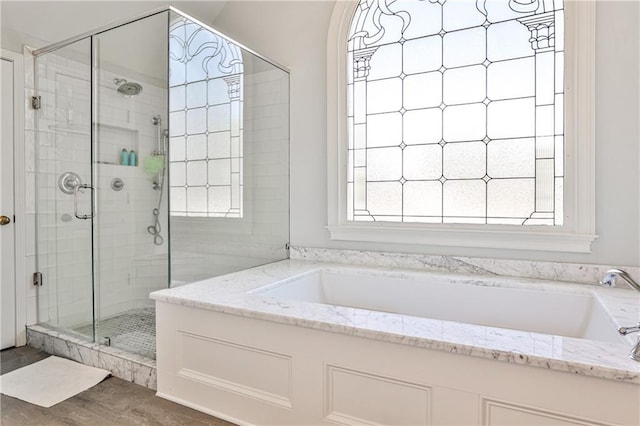 bathroom featuring a shower stall and a garden tub