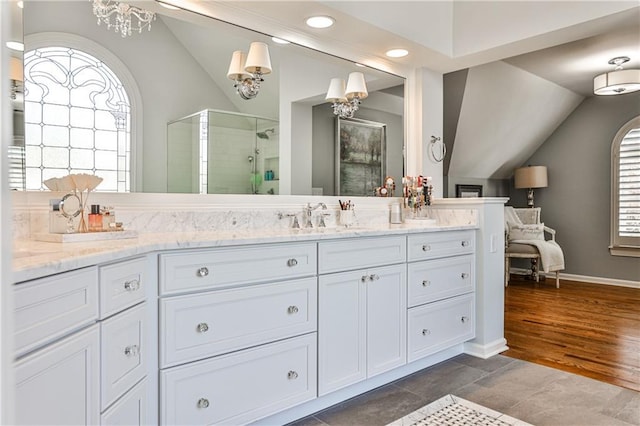 bathroom with a chandelier, a shower stall, vanity, and lofted ceiling