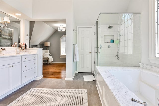 full bathroom with vanity, baseboards, lofted ceiling, a shower stall, and a bath