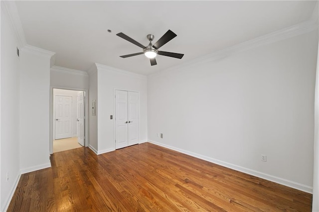 unfurnished bedroom featuring hardwood / wood-style flooring, ornamental molding, a closet, and ceiling fan