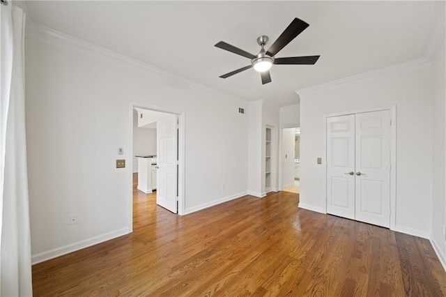 unfurnished bedroom featuring hardwood / wood-style floors, ornamental molding, a closet, and ceiling fan