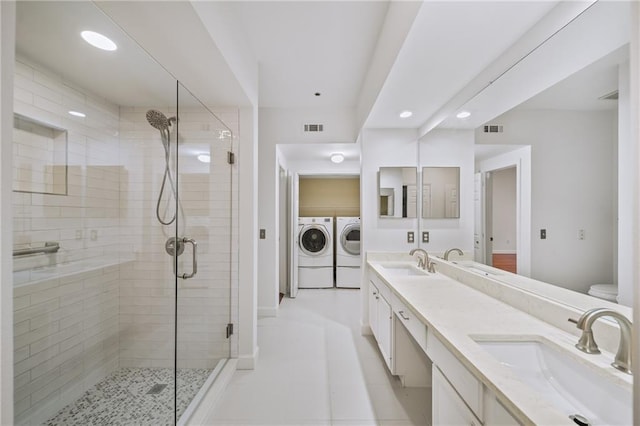 bathroom with vanity, separate washer and dryer, and walk in shower