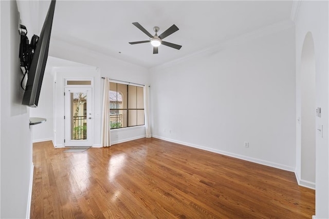 empty room featuring ceiling fan, ornamental molding, and hardwood / wood-style floors