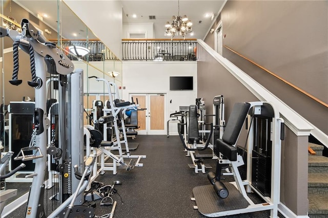 gym with a chandelier and a high ceiling