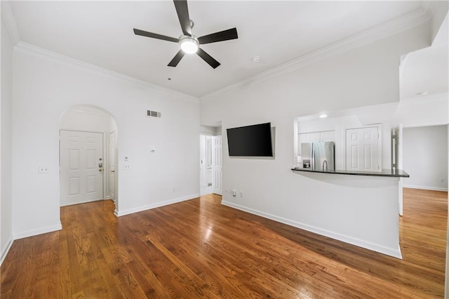 unfurnished living room with ornamental molding, wood-type flooring, and ceiling fan