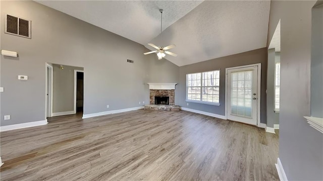 unfurnished living room featuring baseboards, visible vents, light wood finished floors, a fireplace, and ceiling fan