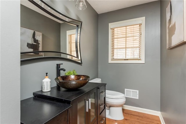 bathroom with hardwood / wood-style flooring, vanity, and toilet