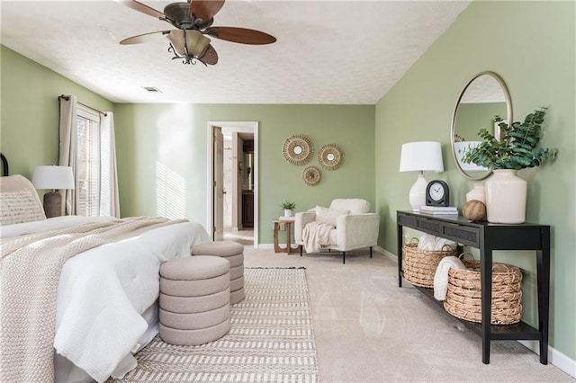 bedroom with ceiling fan, light colored carpet, and a textured ceiling