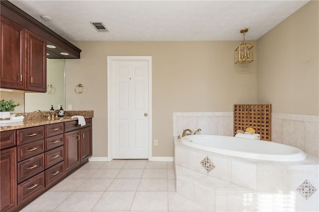 bathroom featuring vanity, tile patterned floors, and tiled bath