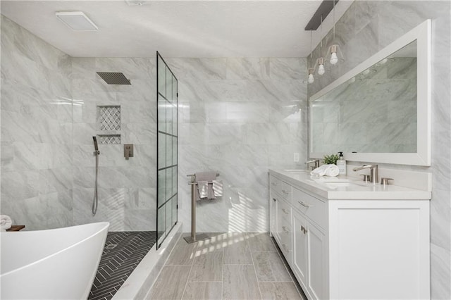 bathroom with shower with separate bathtub, tile walls, and vanity