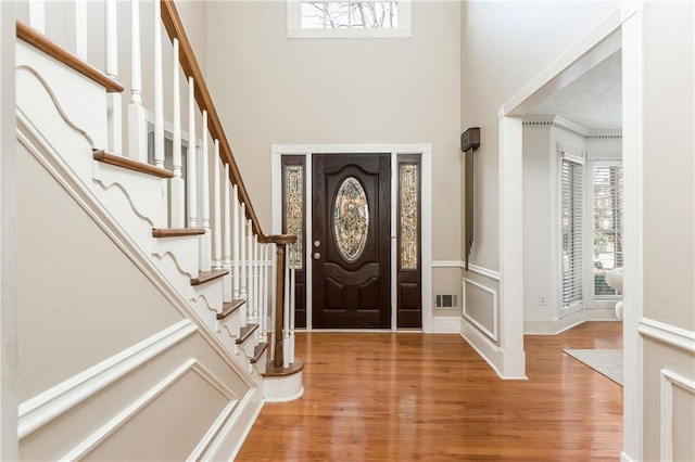 entryway featuring hardwood / wood-style flooring, a healthy amount of sunlight, and a high ceiling