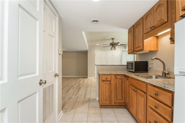 kitchen with sink, ceiling fan, light tile patterned flooring, kitchen peninsula, and white fridge