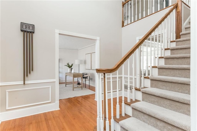 stairs featuring hardwood / wood-style floors and a towering ceiling