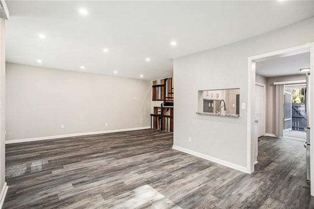 unfurnished living room featuring dark hardwood / wood-style floors and sink