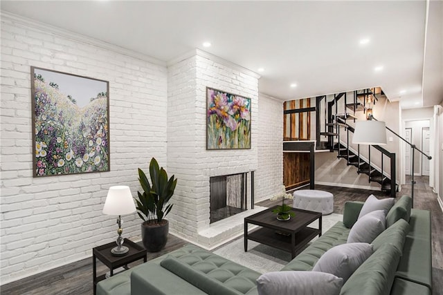 living room featuring hardwood / wood-style floors, brick wall, and a fireplace