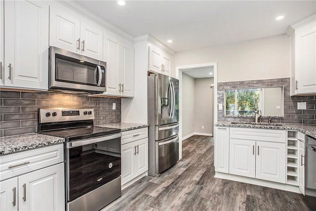 kitchen with sink, appliances with stainless steel finishes, white cabinetry, and dark hardwood / wood-style flooring