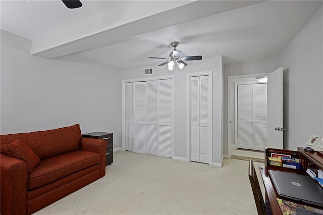 living area featuring light colored carpet and ceiling fan