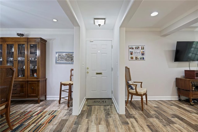 foyer featuring wood-type flooring and ornamental molding