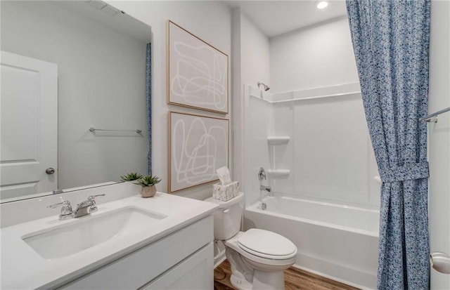 full bathroom featuring toilet, vanity, hardwood / wood-style floors, and shower / bathtub combination with curtain