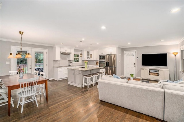 living room featuring baseboards, ornamental molding, dark wood finished floors, and recessed lighting