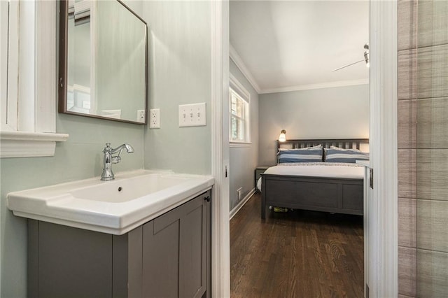 bathroom featuring ornamental molding, vanity, baseboards, and wood finished floors