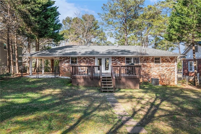 back of house featuring a deck, brick siding, a lawn, and fence