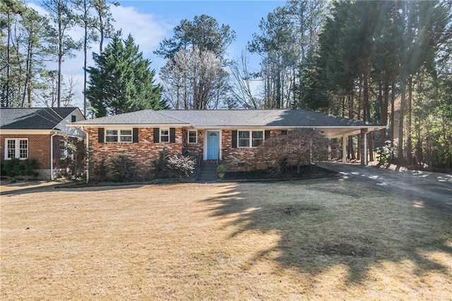 ranch-style house featuring driveway, brick siding, crawl space, and a front yard