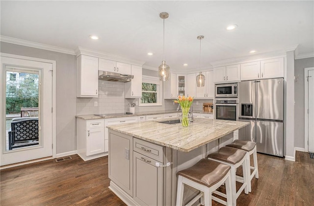 kitchen featuring a healthy amount of sunlight, white cabinets, stainless steel appliances, and crown molding