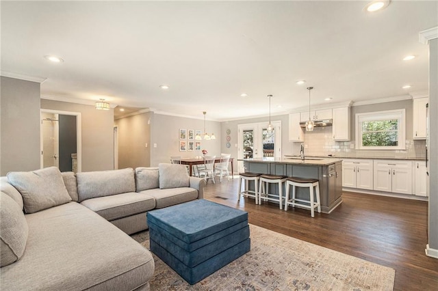 living room featuring ornamental molding, dark wood finished floors, and recessed lighting