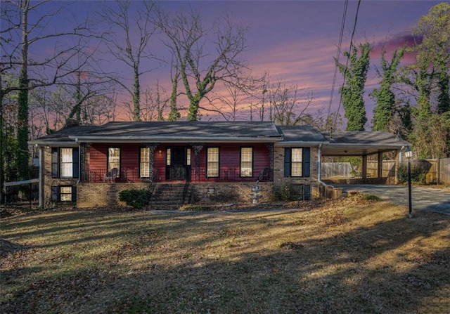 view of front of property with a yard and a carport