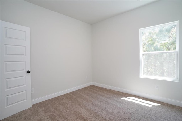 carpeted spare room with baseboards