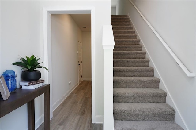 stairway with baseboards and wood finished floors