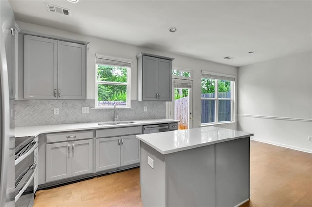 5312 Brooklands Dr, Lithonia, GA 30058 - kitchen with gray cabinetry, appliances with stainless steel finishes, light wood-type flooring, backsplash, and light countertops