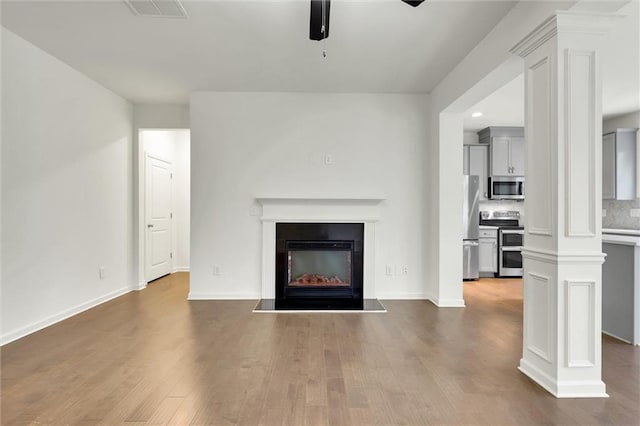 5312 Brooklands Dr, Lithonia, GA 30058 - unfurnished living room featuring a ceiling fan, wood finished floors, a fireplace with raised hearth, and recessed lighting