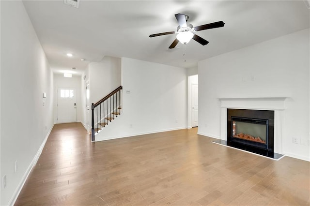 5312 Brooklands Dr, Lithonia, GA 30058 - unfurnished living room featuring stairway, ceiling fan, wood finished floors, and a fireplace with raised hearth